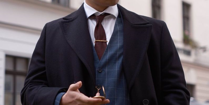Tie Clip - A man in a suit and tie is standing on a street